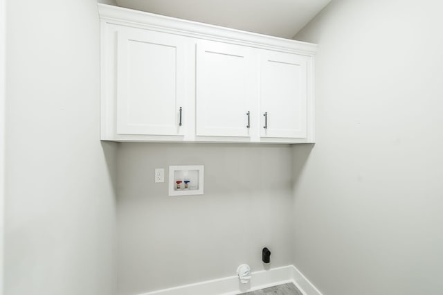 clothes washing area with washer hookup and cabinets