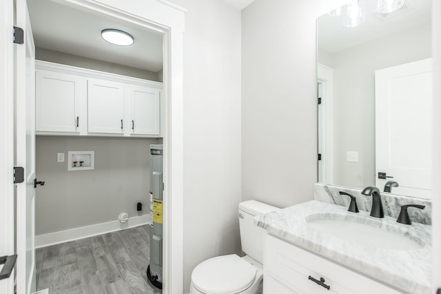 bathroom featuring electric water heater, vanity, toilet, and wood-type flooring