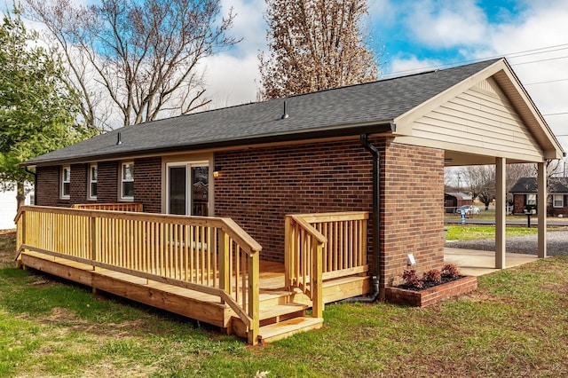 rear view of house featuring a lawn and a deck