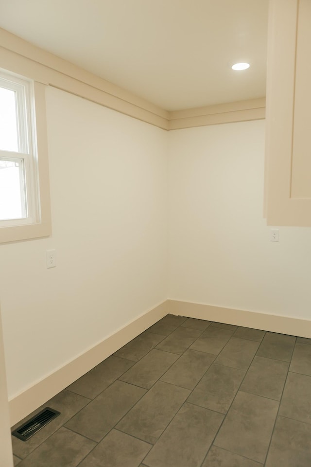 spare room featuring dark tile patterned flooring