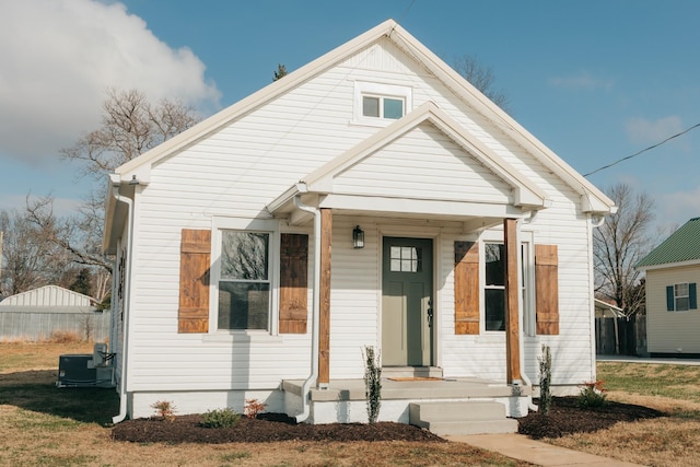 bungalow-style house featuring a front lawn and cooling unit