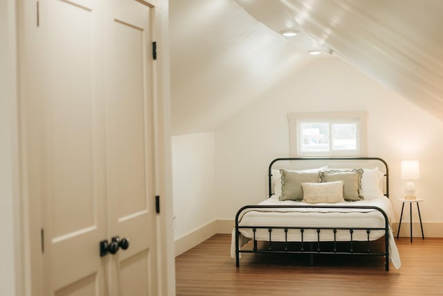 bedroom featuring hardwood / wood-style floors and vaulted ceiling