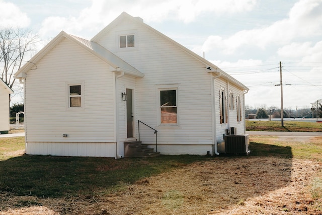 back of house with a lawn and central AC