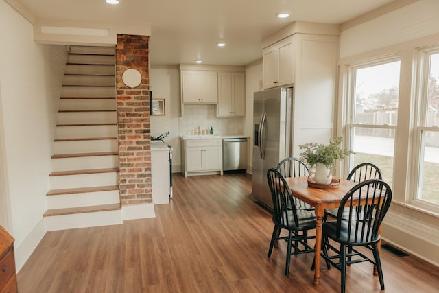 dining room featuring a healthy amount of sunlight and wood-type flooring