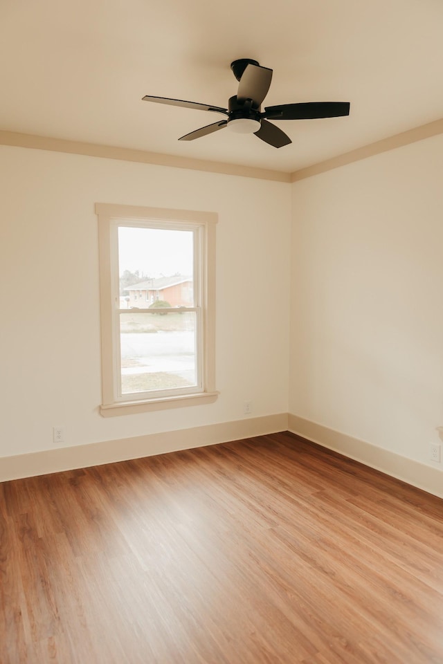 empty room featuring ceiling fan, light hardwood / wood-style floors, and ornamental molding