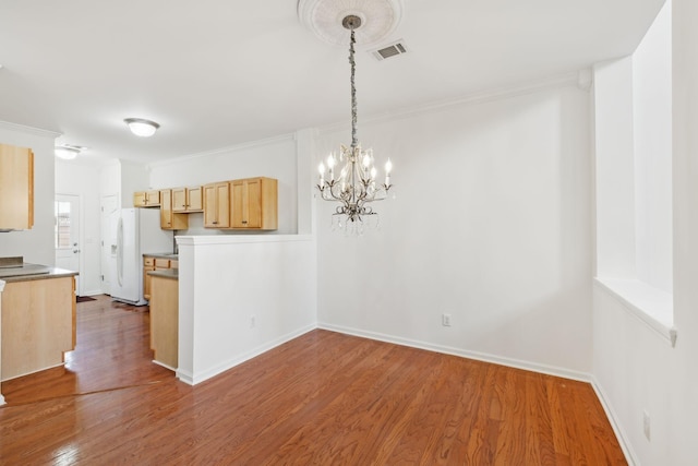 kitchen with dark hardwood / wood-style floors, white refrigerator with ice dispenser, light brown cabinetry, and an inviting chandelier