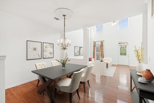 dining area featuring ceiling fan with notable chandelier and light hardwood / wood-style flooring