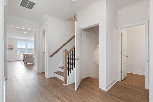 stairway featuring hardwood / wood-style flooring and ornamental molding