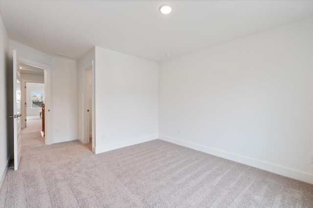 empty room with baseboards, recessed lighting, and light colored carpet