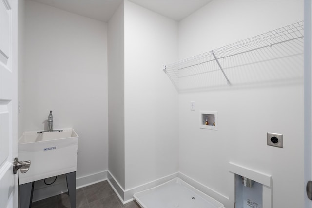 laundry area featuring hookup for an electric dryer, laundry area, washer hookup, dark tile patterned floors, and baseboards