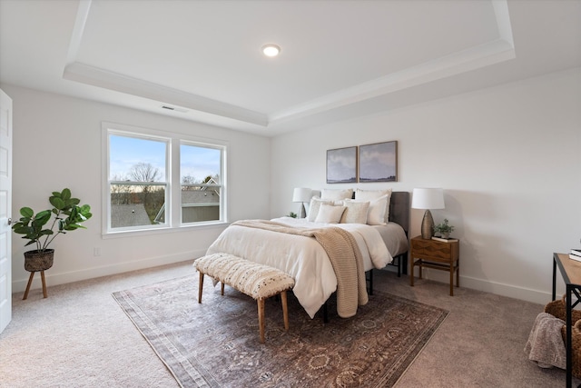 bedroom with carpet flooring, a raised ceiling, visible vents, and baseboards