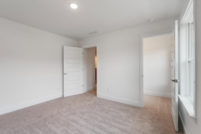 empty room with light carpet and baseboards