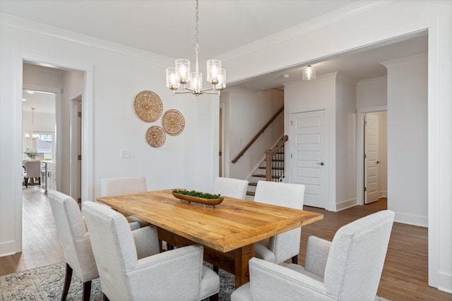 dining room featuring dark wood-type flooring, crown molding, and a chandelier