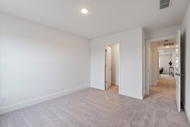 unfurnished bedroom featuring a walk in closet, light colored carpet, and a closet