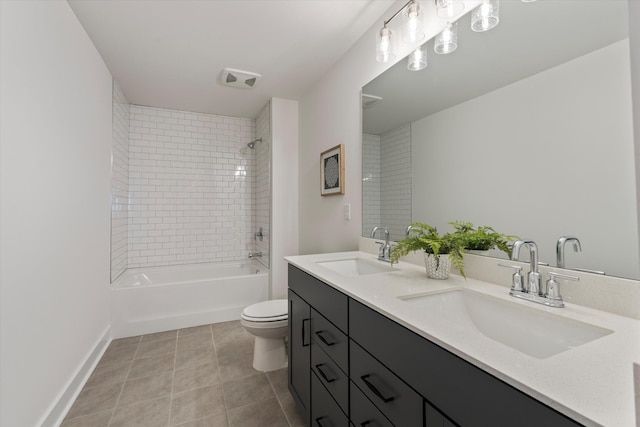 full bathroom featuring tile patterned flooring, tiled shower / bath combo, toilet, and vanity