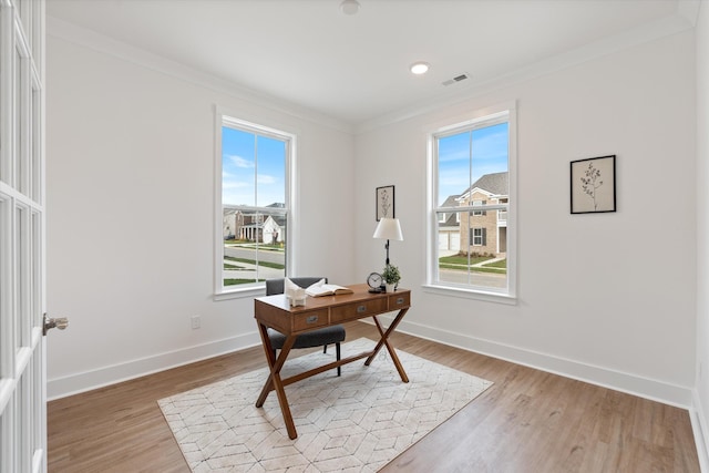 office space with light hardwood / wood-style floors and crown molding