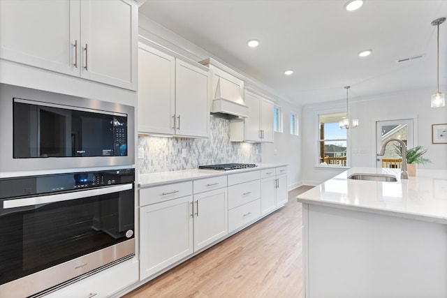 kitchen with light countertops, visible vents, decorative backsplash, appliances with stainless steel finishes, and a sink