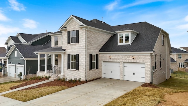 traditional-style home with a garage, concrete driveway, brick siding, and a shingled roof