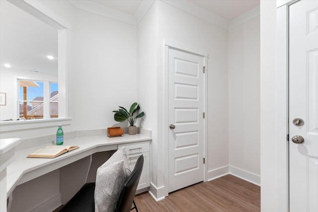 office area featuring crown molding, recessed lighting, built in study area, light wood-type flooring, and baseboards