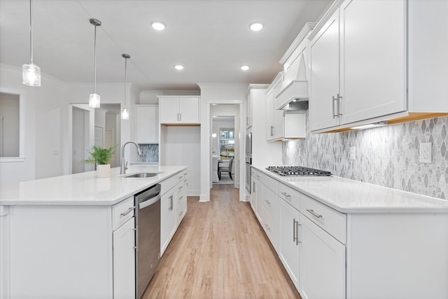 kitchen featuring tasteful backsplash, white cabinets, appliances with stainless steel finishes, ornamental molding, and a sink