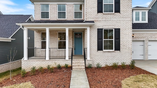 doorway to property with covered porch, driveway, and an attached garage