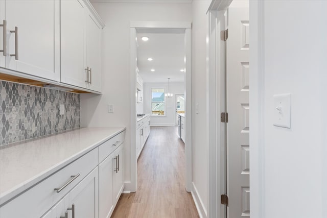 hallway with light wood-type flooring, baseboards, and recessed lighting