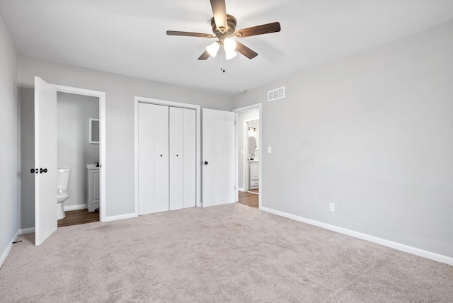 unfurnished bedroom featuring carpet flooring, connected bathroom, ceiling fan, and a closet