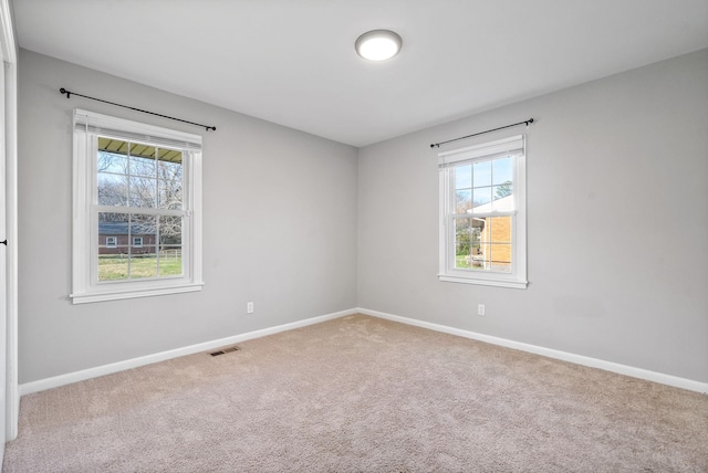 carpeted empty room featuring plenty of natural light