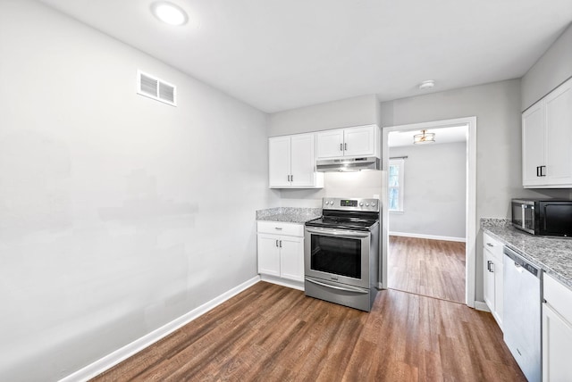 kitchen with white cabinets, appliances with stainless steel finishes, dark hardwood / wood-style floors, and light stone countertops