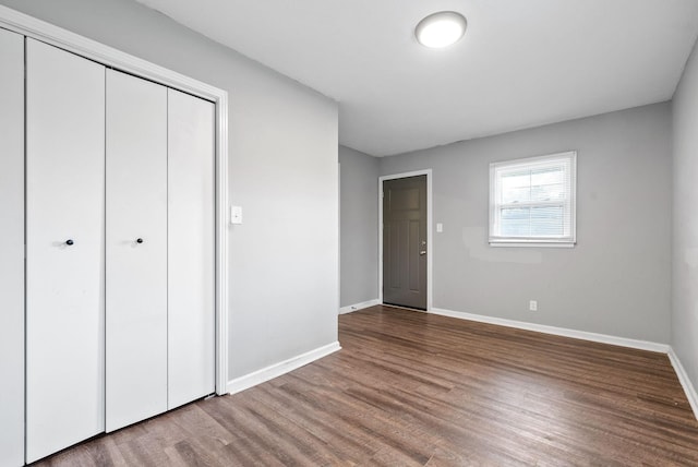 unfurnished bedroom featuring a closet and hardwood / wood-style floors