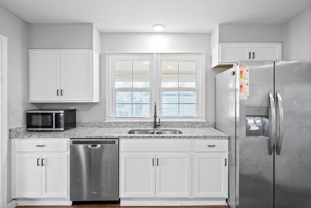 kitchen featuring light stone countertops, sink, white cabinets, and appliances with stainless steel finishes