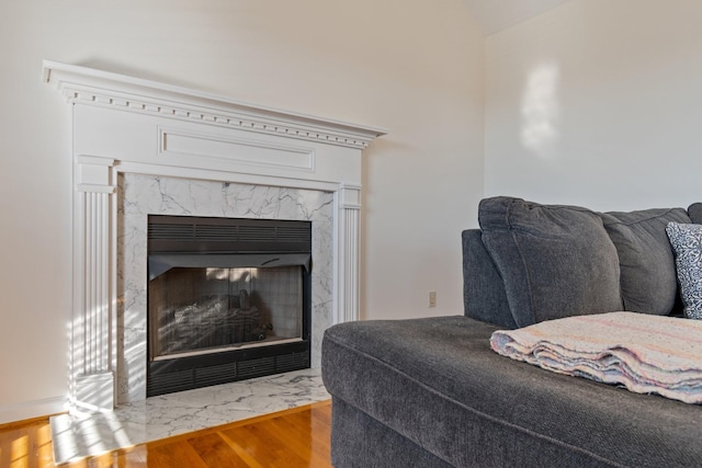 living room with a high end fireplace and hardwood / wood-style flooring