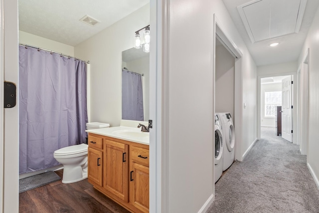 bathroom featuring vanity, hardwood / wood-style flooring, toilet, separate washer and dryer, and curtained shower