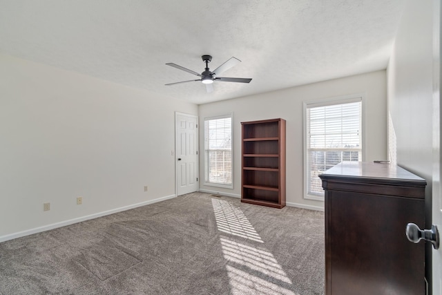 interior space featuring light carpet and ceiling fan