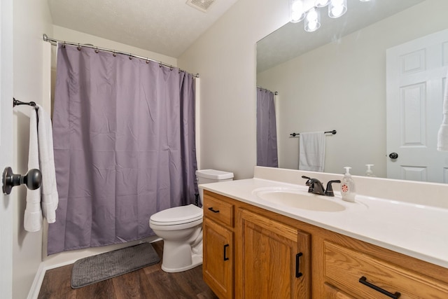 bathroom with hardwood / wood-style floors, vanity, a textured ceiling, and toilet