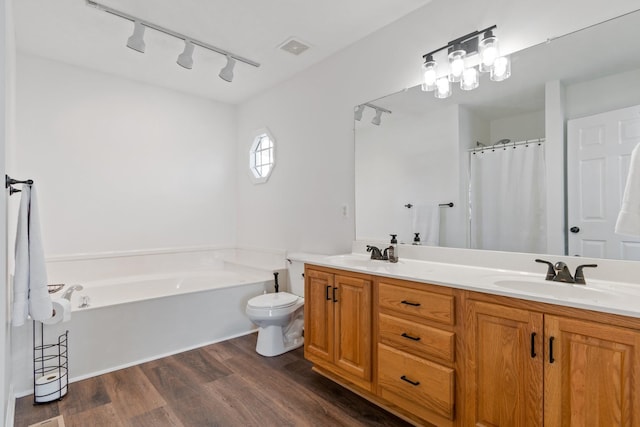 bathroom featuring wood-type flooring, vanity, toilet, and a tub