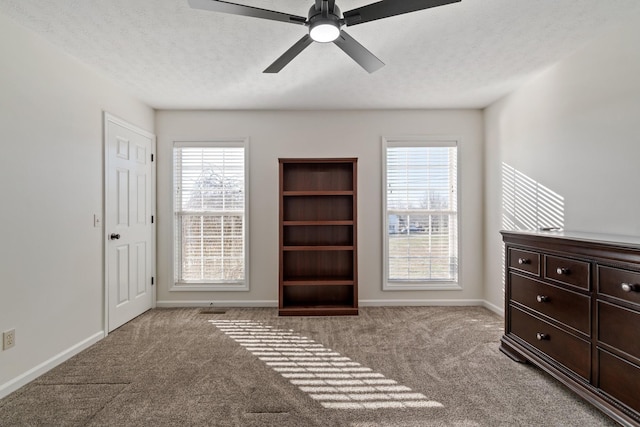 interior space featuring ceiling fan, light colored carpet, and a textured ceiling