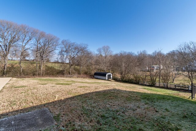 view of yard featuring a rural view and a shed