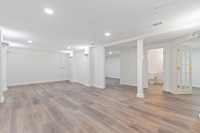 basement featuring hardwood / wood-style flooring and a drop ceiling