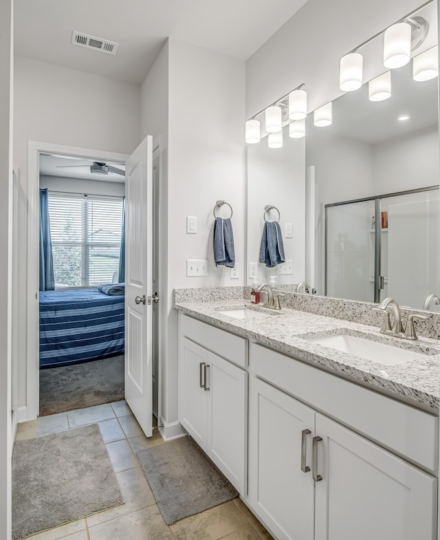 bathroom with tile patterned floors, a shower with door, and vanity