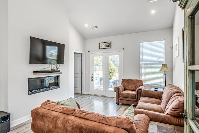 living room with vaulted ceiling and light wood-type flooring