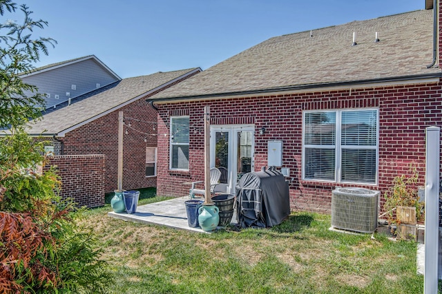 rear view of property with a lawn, central AC, and a patio