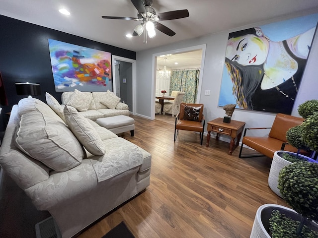 living room featuring hardwood / wood-style floors and ceiling fan with notable chandelier