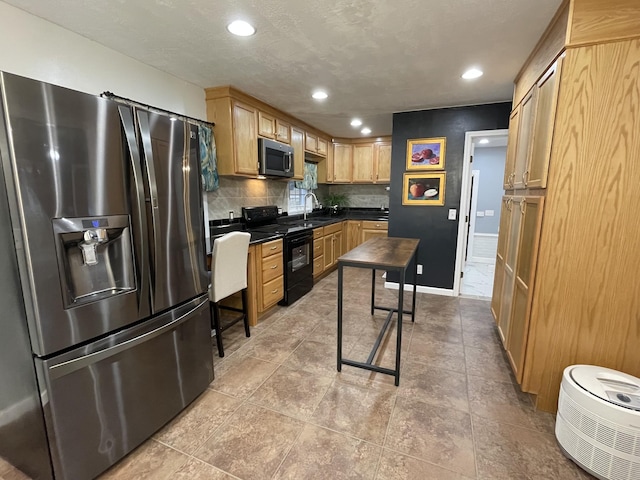 kitchen featuring decorative backsplash, light brown cabinets, sink, and stainless steel appliances