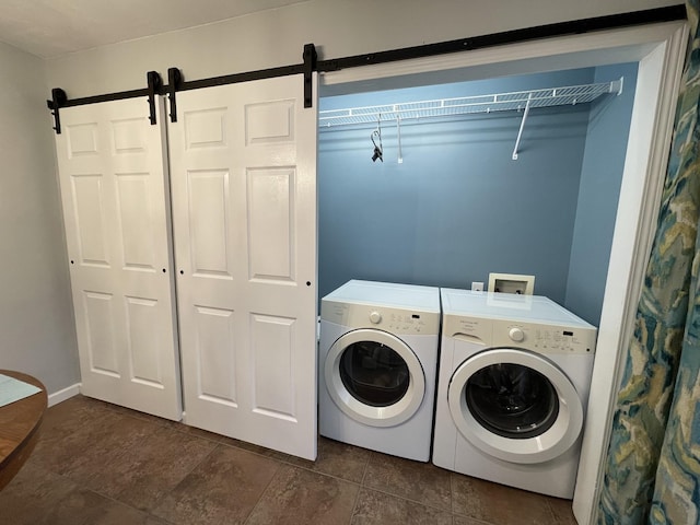 laundry room with a barn door and independent washer and dryer