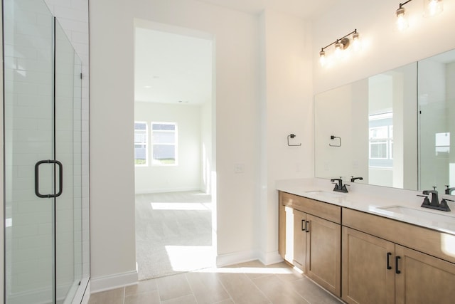 bathroom with a shower with door, vanity, and tile patterned flooring