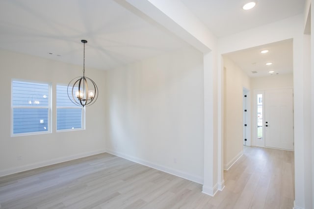 interior space with a healthy amount of sunlight, light hardwood / wood-style flooring, and a notable chandelier