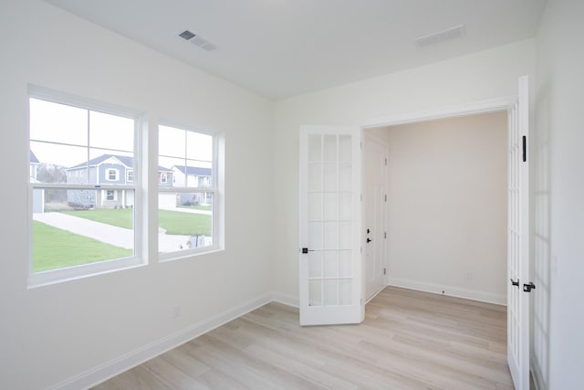 unfurnished room with french doors and light hardwood / wood-style floors