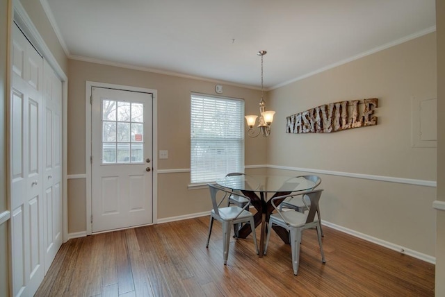 dining area featuring hardwood / wood-style floors, a chandelier, and ornamental molding