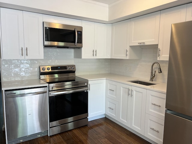 kitchen with sink, tasteful backsplash, dark hardwood / wood-style flooring, white cabinets, and appliances with stainless steel finishes